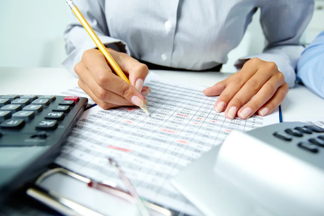 Registro detallado de operaciones numéricas realizado en los servicios contables que garantizan transparencia en la contabilidad. Análisis de cifras con lápiz y calculadora, tarea esencial dentro de los servicios contables para mantener orden financiero.