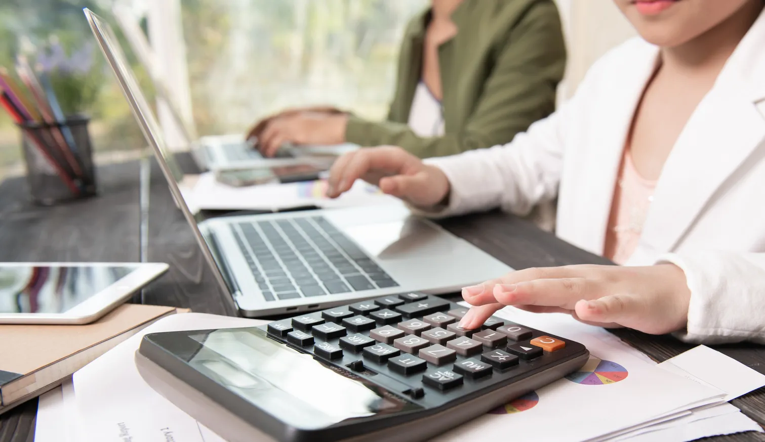 Profesional organizando reportes financieros en computadora como parte de los servicios contables aplicados en oficinas corporativas. Uso de herramientas digitales para llevar a cabo servicios contables modernos y eficientes en la gestión empresarial.