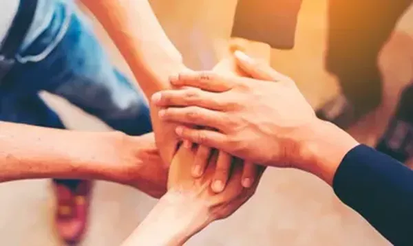 Fotografía desde arriba de varias manos juntas en representación del compromiso con la administración de condominios CDMX.